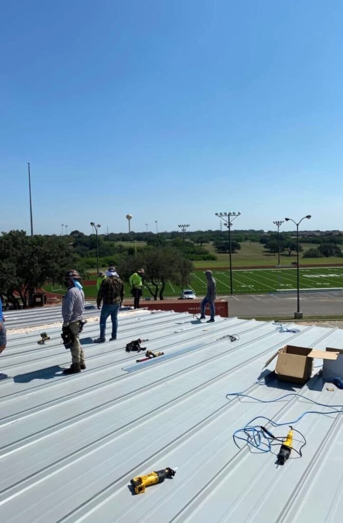 Cool Roofs crew installing new roof on San Marcos Academy building in Texas