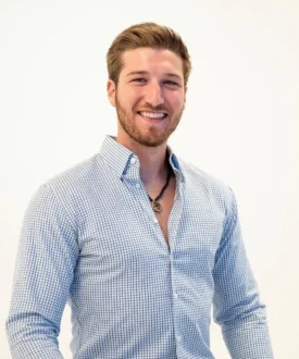 Smiling man in a blue checkered shirt, representing Cool Roofs, emphasizing roofing expertise and customer service for hail damage inspections.