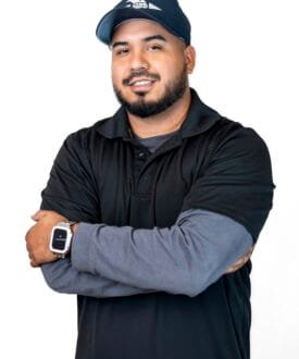 Professional technician from Cool Roofs wearing a black polo shirt and cap, showcasing expertise in roofing services.