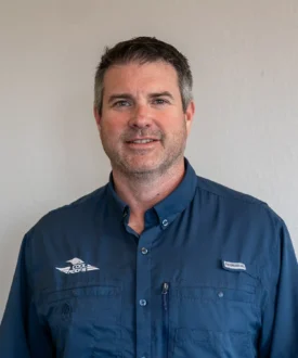 Man in blue work shirt representing Cool Roofs, showcasing expertise in roofing services and hail damage inspections.