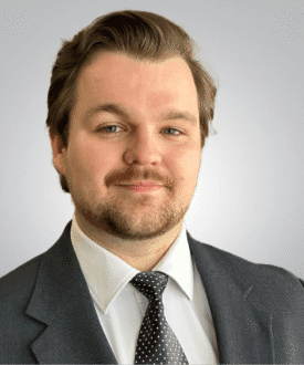 Professional headshot of a man in a suit and tie, representing expertise in roofing services and hail damage inspections for Cool Roofs.