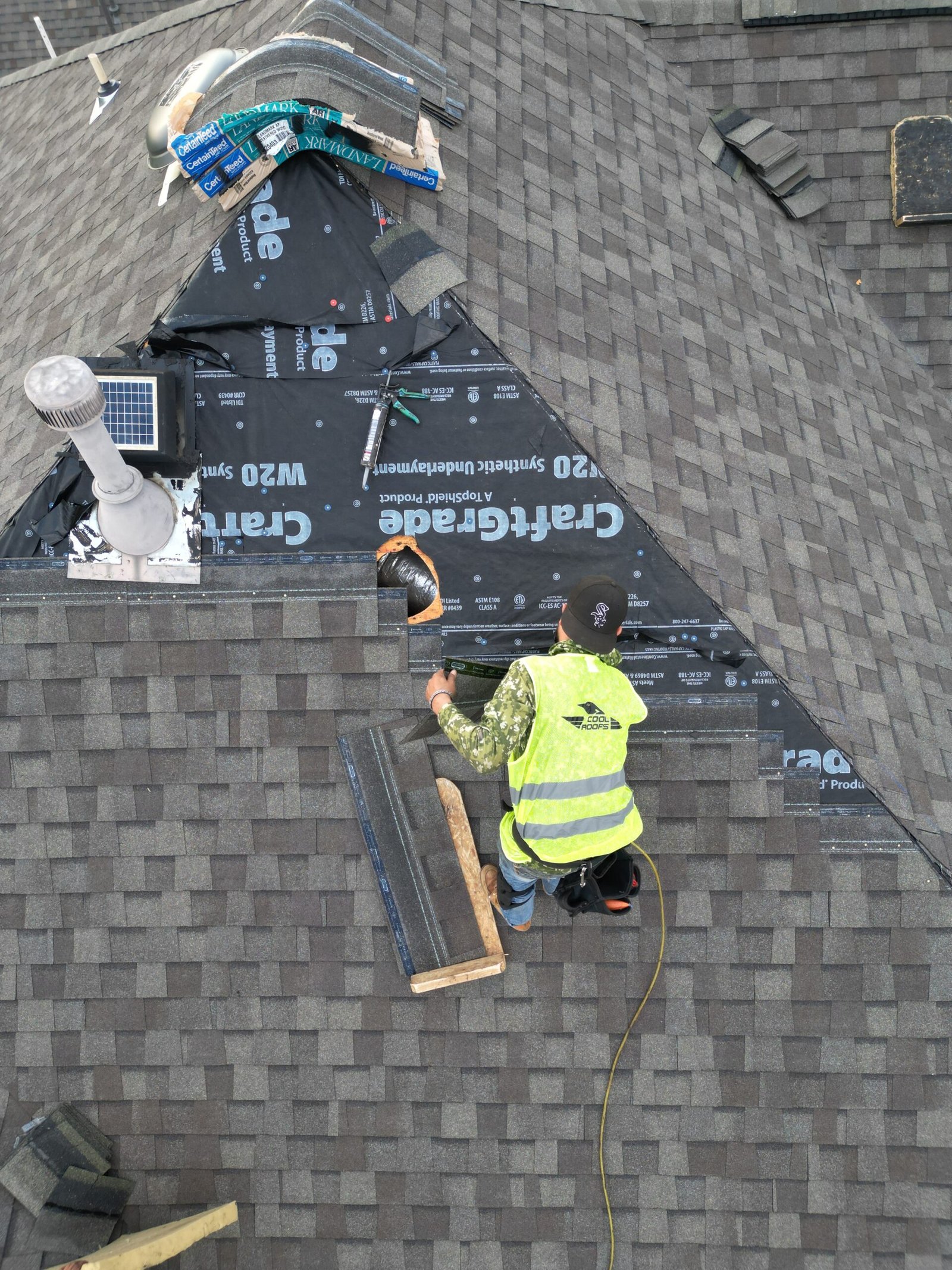 Roofing contractor installing shingles on residential roof, showcasing Cool Roofs branding and professional expertise in roofing solutions.