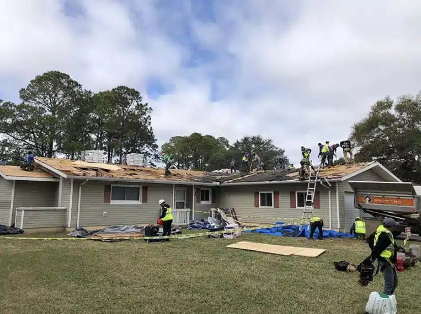 Roof replacement project at Fort Carson, Colorado, featuring multiple workers installing GAF Timberline® shingles on residential barracks.