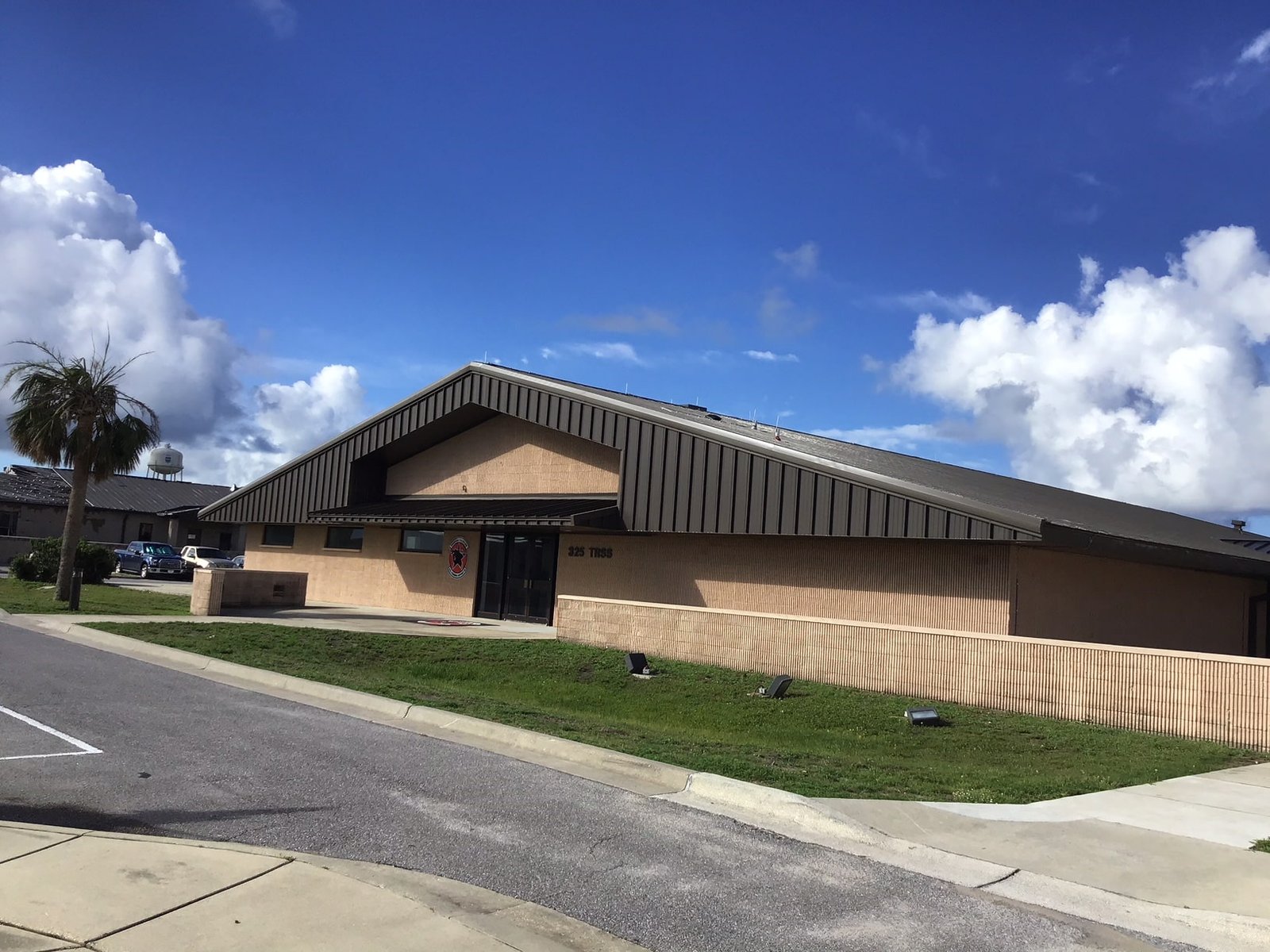 Tyndall Air Force Base building with modern roofing, showcasing GAF Timberline® shingles under a blue sky, emphasizing military and residential project focus.