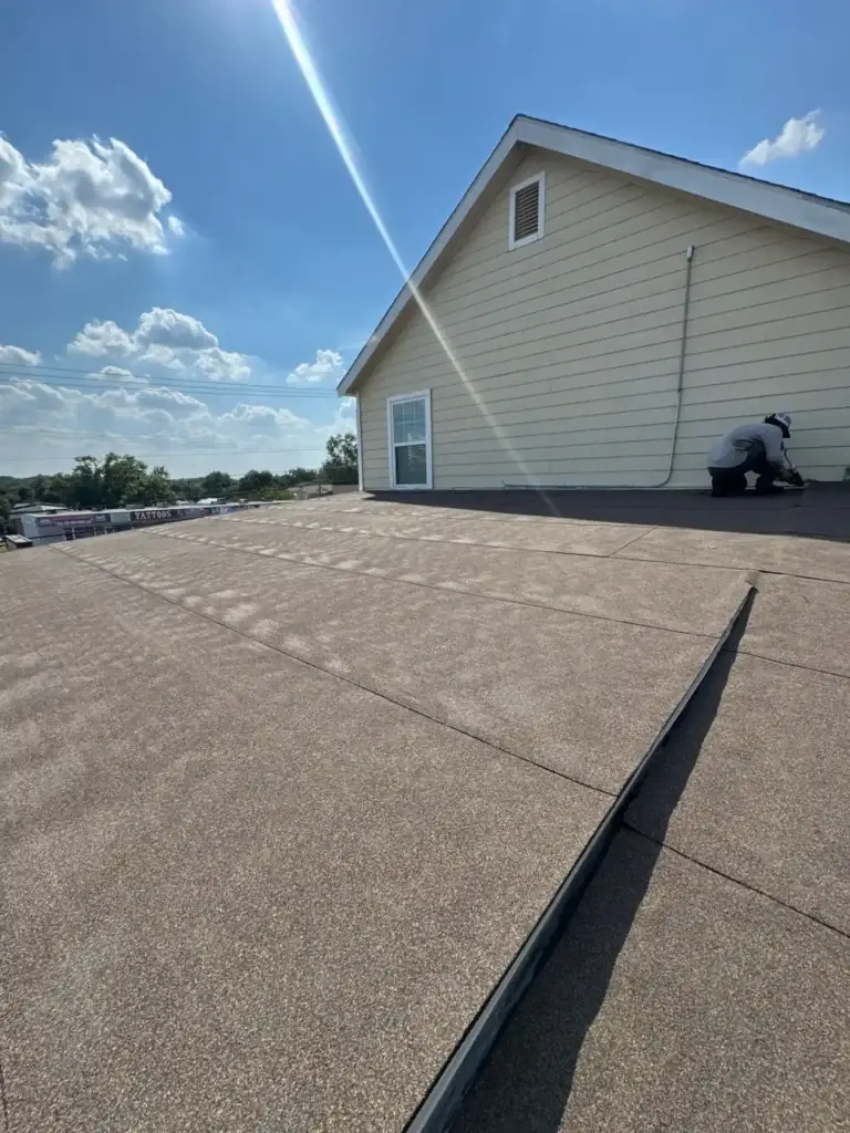 Cool Roofs worker installing Mulehide roofing material on commercial flat roof in San Antonio, TX.