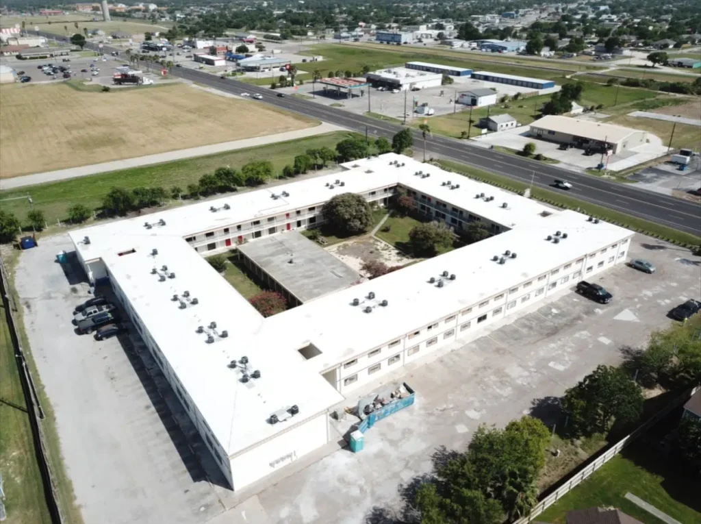 Commercial building with restored TPO roof, aerial view illustrating roof restoration process.