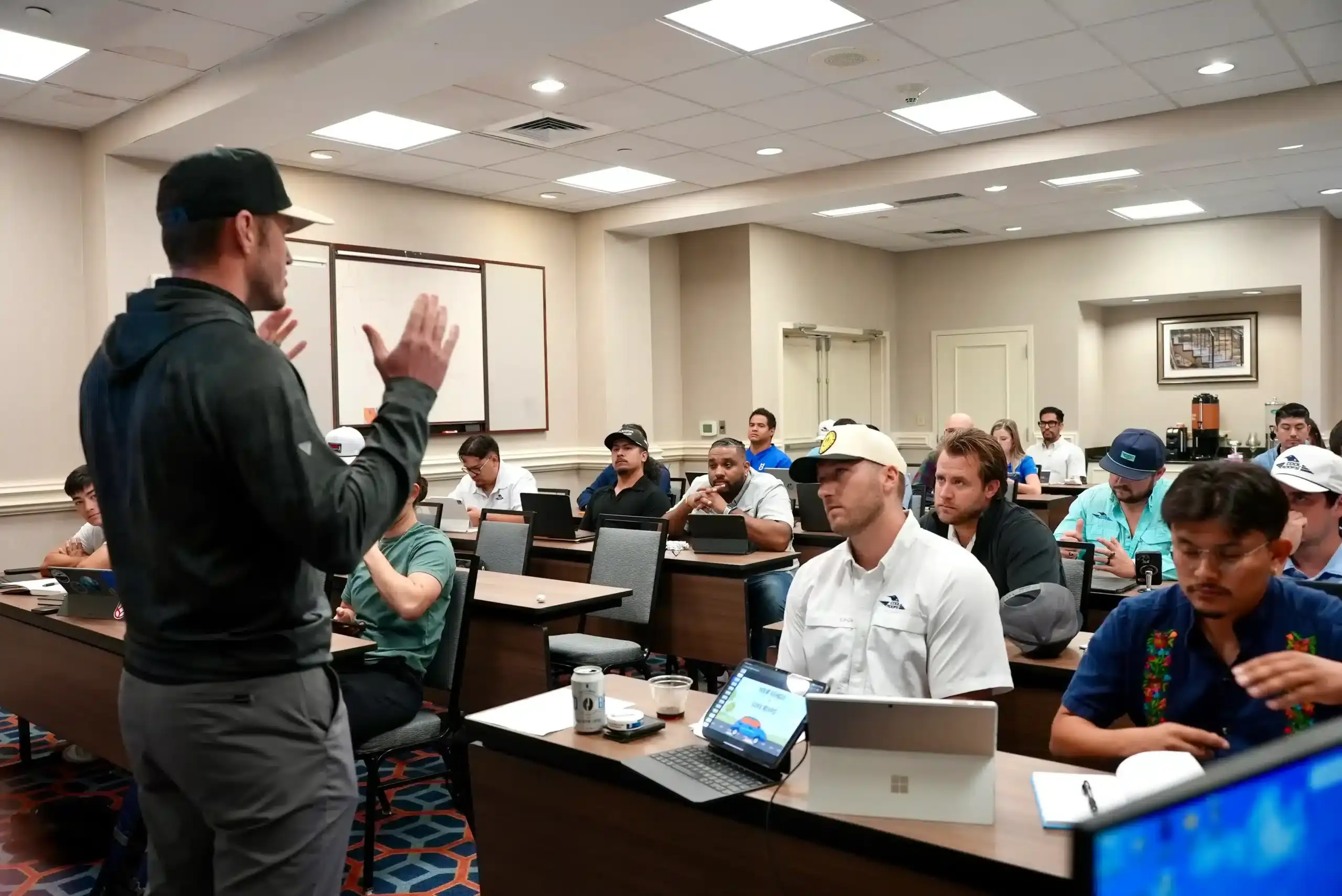 Cool Roofs sales training cohort in conference room, experienced closers learning sales strategies.