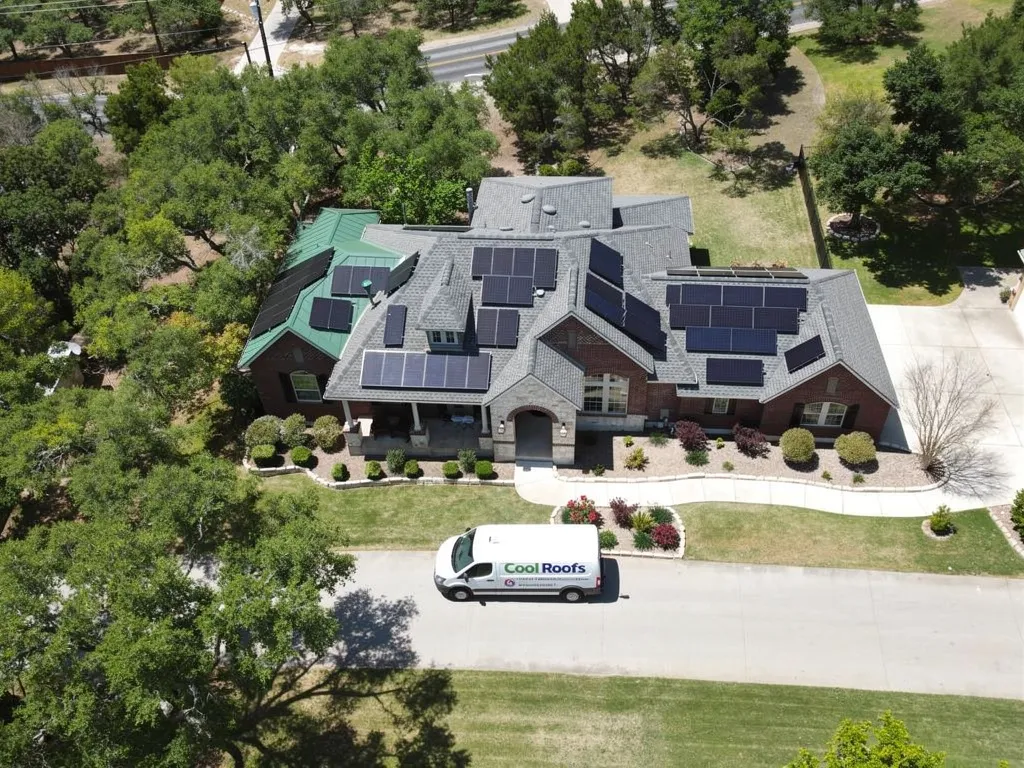 Aerial view of home with solar panels and Cool Roofs installation van
