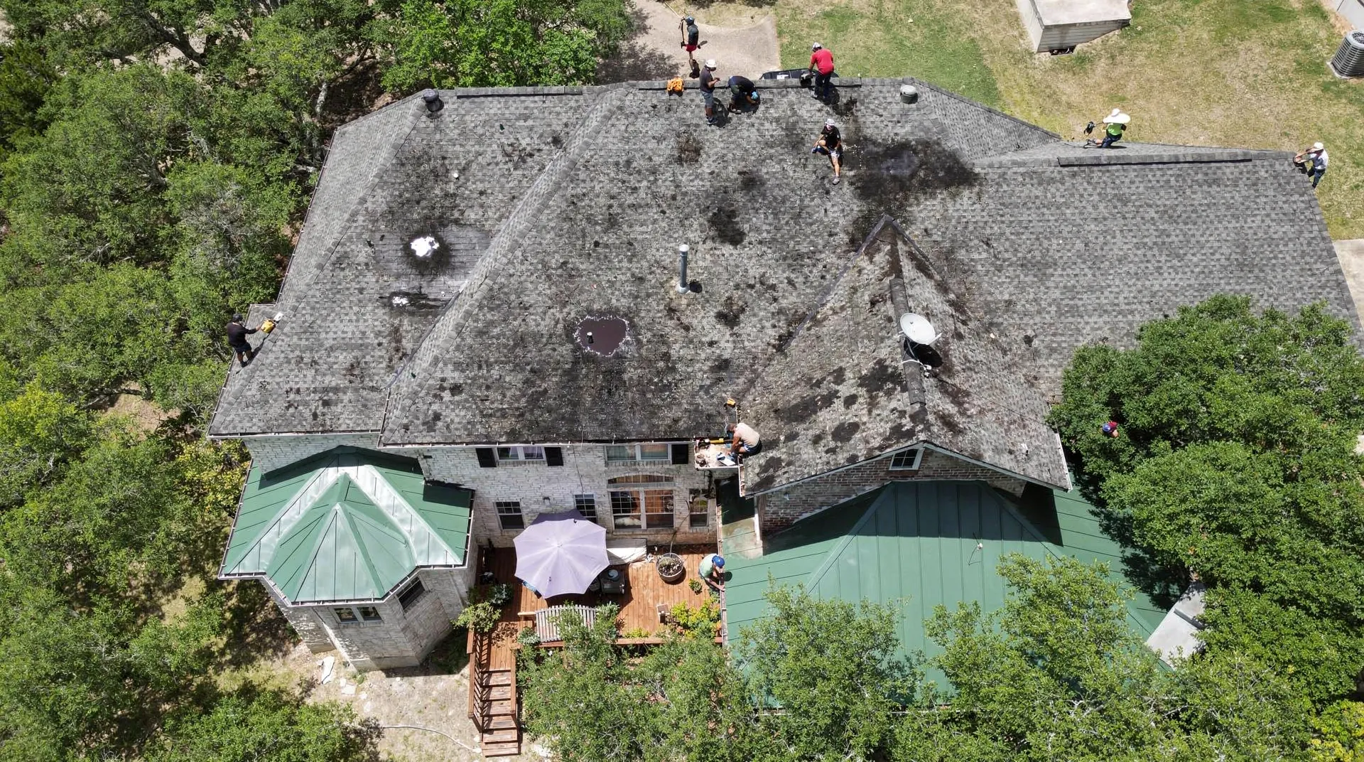 Early warning signs of roof problems include water dripping from the ceiling, pooling water